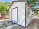 A small, well-maintained outbuilding features white siding and brown trim at 1024 Campbell Ave, Lake Wales, FL 33853