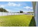 Large, green backyard enclosed with a white vinyl fence for added privacy at 1045 Montgomery Ln, Polk City, FL 33868