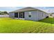 View of the home's backyard featuring lush green grass and a screened in lanai at 1045 Montgomery Ln, Polk City, FL 33868
