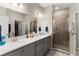 Modern bathroom featuring double sinks, quartz countertops, and a tiled shower with glass door at 1045 Montgomery Ln, Polk City, FL 33868