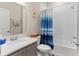 Bathroom offers a modern vanity with sink and tiled shower with blue-striped curtain at 1045 Montgomery Ln, Polk City, FL 33868