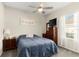 Bedroom with neutral walls, fan, TV on chest and bright window with sheer curtains at 1045 Montgomery Ln, Polk City, FL 33868