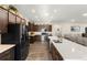 Bright, spacious kitchen with stainless steel appliances, dark cabinets, an island with a quartz countertop, and wood-look floors at 1045 Montgomery Ln, Polk City, FL 33868