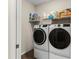 Modern laundry room featuring front loading washer and dryer with overhead shelf at 1045 Montgomery Ln, Polk City, FL 33868