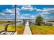 Backyard view with sidewalk leading to boat dock, enhancing the waterfront living experience at 108 Lake Howard Dr Nw, Winter Haven, FL 33880