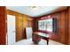 Bedroom with wood paneling, desk, and bright window with plantation shutters at 108 Lake Howard Dr Nw, Winter Haven, FL 33880