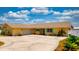 Bright yellow home featuring a spacious driveway, turquoise shutters, and a well-maintained landscape at 108 Lake Howard Dr Nw, Winter Haven, FL 33880