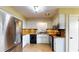Well-lit kitchen features stainless steel appliances, tile floors, and white cabinetry at 108 Lake Howard Dr Nw, Winter Haven, FL 33880