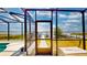 Scenic view of the water and boat dock from a screened-in patio, offering peaceful waterfront living at 108 Lake Howard Dr Nw, Winter Haven, FL 33880