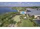 Aerial view showcases a community clubhouse with bocce ball, pool, outdoor seating, and lush landscaping at 1104 Sawgrass Dr, Winter Haven, FL 33884