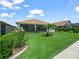 Beautifully landscaped backyard with lush green lawn, patio, trees and shrubs at 1104 Sawgrass Dr, Winter Haven, FL 33884