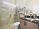 Modern bathroom features a walk-in shower, wood cabinets, and black granite countertops at 1104 Sawgrass Dr, Winter Haven, FL 33884