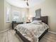 Cozy bedroom features a dark wood bedframe, neutral paint and plenty of natural light at 1104 Sawgrass Dr, Winter Haven, FL 33884