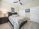 Cozy bedroom features a wood accent wall, neutral paint and ceiling fan at 1104 Sawgrass Dr, Winter Haven, FL 33884