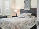 Bright bedroom features a dark wood bedframe, neutral paint and natural light from large window at 1104 Sawgrass Dr, Winter Haven, FL 33884