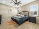 Relaxing bedroom features a ceiling fan, wood-look flooring, and neutral decor at 1104 Sawgrass Dr, Winter Haven, FL 33884