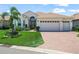 Charming home featuring a well-manicured lawn and a two car garage with a brick paved driveway at 1104 Sawgrass Dr, Winter Haven, FL 33884