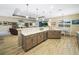 An open kitchen with counter seating, a double sink, wooden cabinets, tile floors, and stainless steel appliances at 1104 Sawgrass Dr, Winter Haven, FL 33884