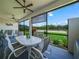 The screened lanai features a dining set and a scenic view of the lush backyard at 1104 Sawgrass Dr, Winter Haven, FL 33884