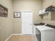 Bright laundry room features modern white washer and dryer and shelving at 1104 Sawgrass Dr, Winter Haven, FL 33884