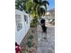 The fenced backyard features a stone paver area with a grill and tropical foliage at 124 Palm Pl, Haines City, FL 33844