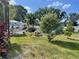 Landscaped backyard featuring a fire pit, lush green lawn, and various trees for outdoor relaxation at 124 Palm Pl, Haines City, FL 33844