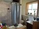 Bathroom featuring shower with shower curtain, and a window with plants above the toilet and sink at 124 Palm Pl, Haines City, FL 33844