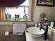 This bathroom features a white vessel sink, dark faucet, tile flooring, window, and dark trim at 124 Palm Pl, Haines City, FL 33844