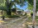 View of the home's exterior, surrounded by lush greenery and mature trees at 124 Palm Pl, Haines City, FL 33844