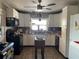 Traditional kitchen with white cabinets, dark appliances, tile floors and a view from the kitchen window at 124 Palm Pl, Haines City, FL 33844