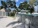Backyard with a white sandy area, above ground pool, lush landscaping, and storage sheds at 124 Palm Pl, Haines City, FL 33844