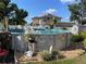 View of above ground pool with rock landscaping, flowers, and view of the solar panels on the house at 124 Palm Pl, Haines City, FL 33844