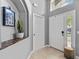 Bright foyer with tile flooring; white painted walls with a decorative nook and a large front door at 1357 Rebecca Dr, Haines City, FL 33844