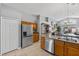 Well-lit kitchen with stainless steel appliances, wood cabinets, and tile flooring at 1357 Rebecca Dr, Haines City, FL 33844