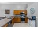 An efficient kitchen with wood cabinets, tile floors, and stainless steel appliances at 1357 Rebecca Dr, Haines City, FL 33844