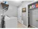 Functional laundry room with washer, dryer, and storage shelves at 1357 Rebecca Dr, Haines City, FL 33844