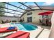 Beautiful screened-in pool with comfortable lounge chairs and dining area at 1357 Rebecca Dr, Haines City, FL 33844