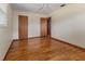 A bedroom with hardwood floors, a ceiling fan, neutral paint, and two closets/doorways at 1371 Sheridan Sw St, Winter Haven, FL 33880