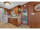 A charming kitchen features warm wood cabinetry, a tile backsplash, and a doorway to the outside at 1371 Sheridan Sw St, Winter Haven, FL 33880