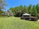 Spacious backyard featuring a charming gazebo surrounded by manicured landscaping, creating a serene outdoor oasis at 14 Cypress Run, Haines City, FL 33844