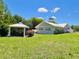 Expansive backyard featuring a gazebo, lush lawn, and manicured landscaping, perfect for outdoor activities and relaxation at 14 Cypress Run, Haines City, FL 33844