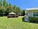 Side view of the home with a gazebo featuring a lush backyard, manicured landscaping, and a tranquil setting at 14 Cypress Run, Haines City, FL 33844