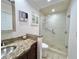 Bathroom featuring granite countertops, dark wood cabinets, and a glass-enclosed shower for a contemporary feel at 14 Cypress Run, Haines City, FL 33844