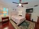 Cozy main bedroom features wood floors, a ceiling fan, and bright natural lighting at 14 Cypress Run, Haines City, FL 33844