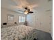 Bright bedroom featuring a ceiling fan, window with shutters, and neutral-toned decor at 14 Cypress Run, Haines City, FL 33844