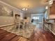Spacious dining room featuring wood floors, a gray rug, and adjacent kitchen with bar seating at 14 Cypress Run, Haines City, FL 33844