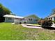 Charming single-story home boasts a metal roof, covered deck, and a meticulously landscaped yard with lush bamboo at 14 Cypress Run, Haines City, FL 33844