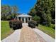 A beautiful gazebo surrounded by landscaping, offering a tranquil outdoor space at 14 Cypress Run, Haines City, FL 33844