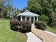 Lush garden view of the gazebo with a brick path and surrounding landscaping at 14 Cypress Run, Haines City, FL 33844