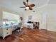 Hardwood-floored office with built-in shelving, desk, and a ceiling fan at 14 Cypress Run, Haines City, FL 33844